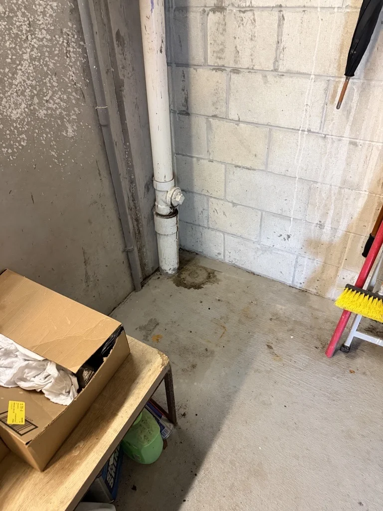 Commercial jobsite before temporary utility sink installation showing existing plumbing connection